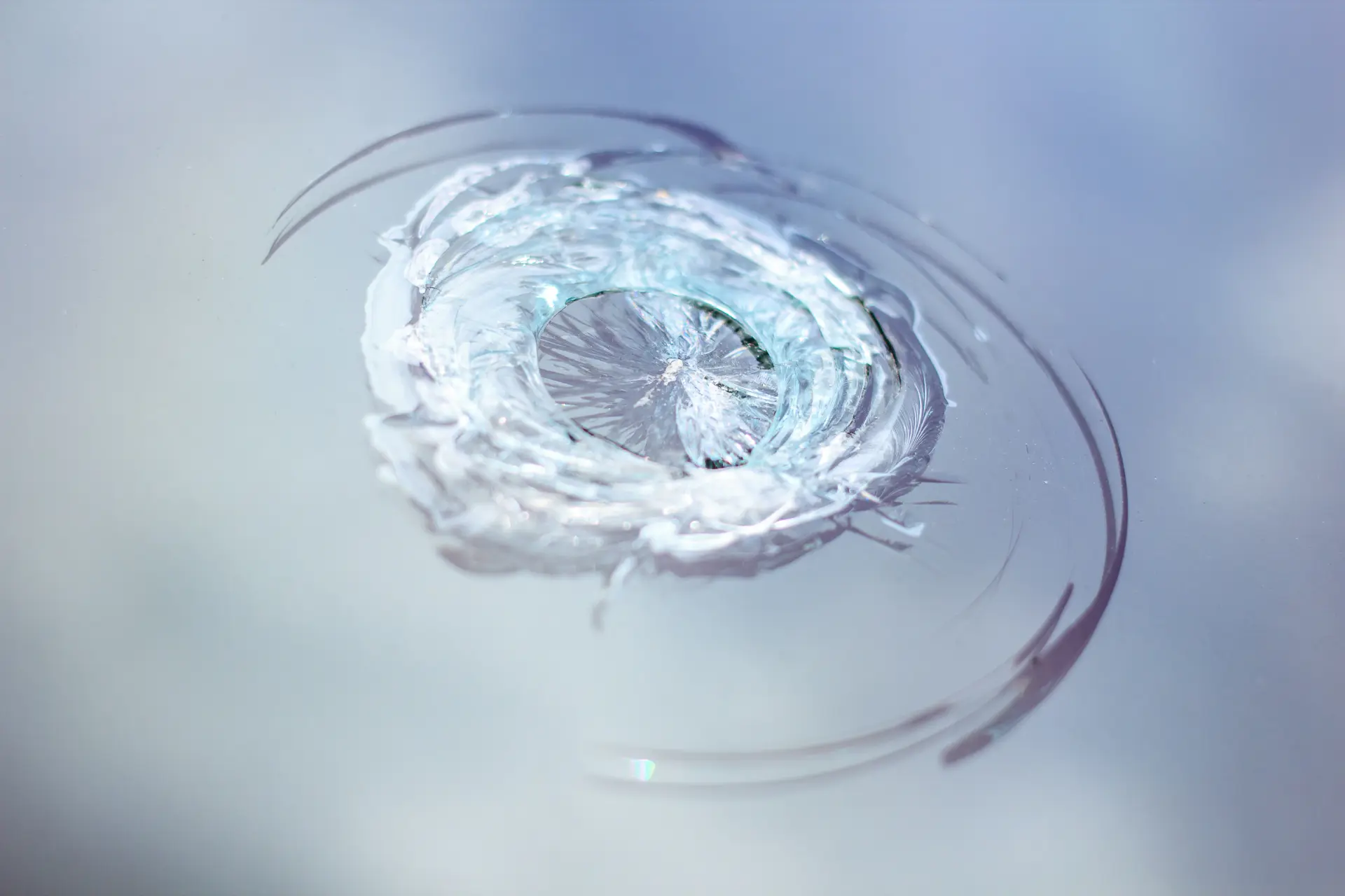 Macro close-up of a bullseye windscreen chip on a white background